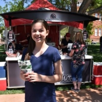 Abby in front of a Totally Nutz kiosk